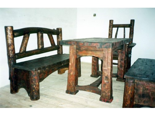 Masywny drewniany stół z dwoma  ławkami i krzesłami.